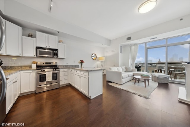 kitchen featuring white cabinets, appliances with stainless steel finishes, and kitchen peninsula