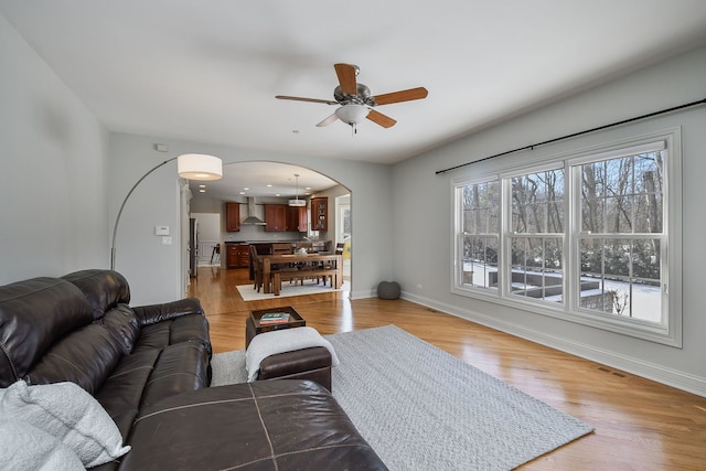 living room featuring light wood-type flooring and ceiling fan