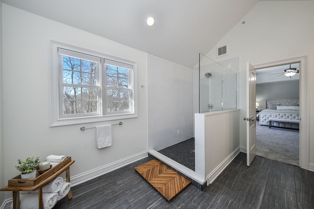 bathroom with hardwood / wood-style flooring, ceiling fan, vaulted ceiling, and tiled shower