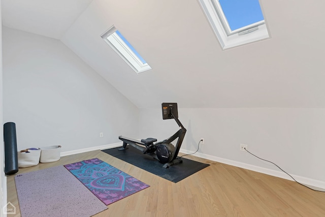 workout area featuring wood-type flooring and lofted ceiling with skylight