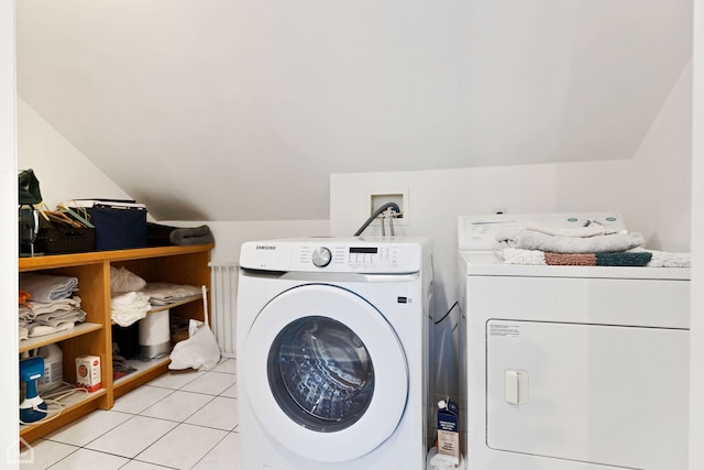 laundry area with light tile patterned floors and washing machine and dryer