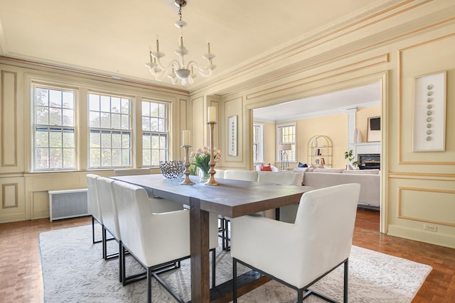 dining room with ornamental molding, radiator, and an inviting chandelier