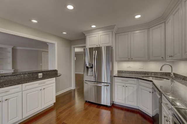 kitchen featuring white cabinetry, stainless steel appliances, sink, and dark stone counters