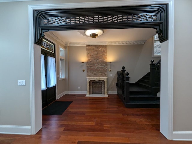 entryway with a fireplace, dark hardwood / wood-style floors, and ornamental molding