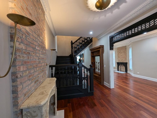 staircase featuring crown molding, a fireplace, and wood-type flooring