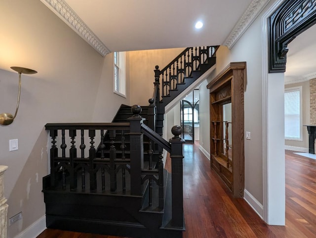 stairway with crown molding and wood-type flooring