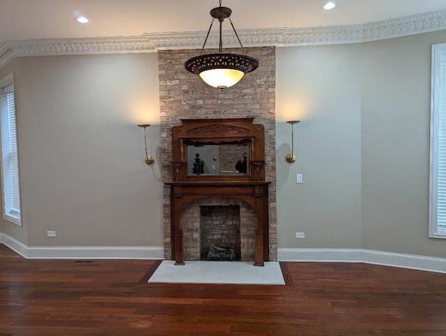 unfurnished living room with crown molding, dark hardwood / wood-style flooring, and a brick fireplace