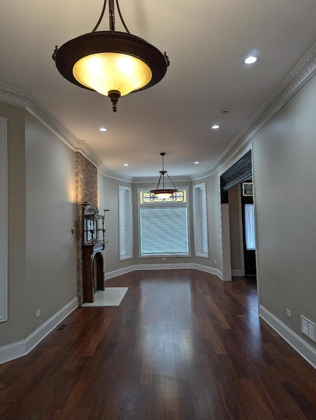 unfurnished living room featuring dark hardwood / wood-style flooring and ornamental molding