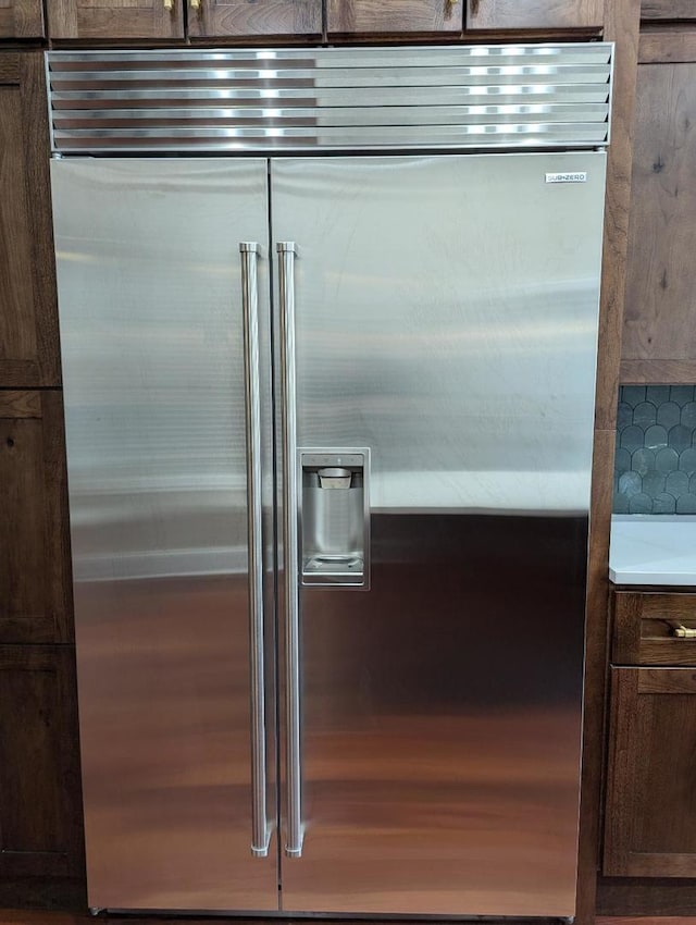 interior details featuring high end refrigerator and dark brown cabinets