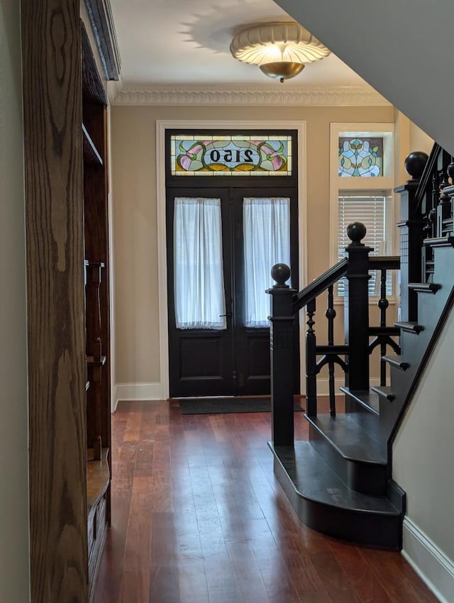 foyer featuring french doors, dark hardwood / wood-style floors, and ornamental molding