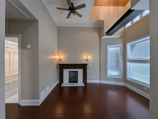 unfurnished living room featuring crown molding, dark hardwood / wood-style flooring, and ceiling fan