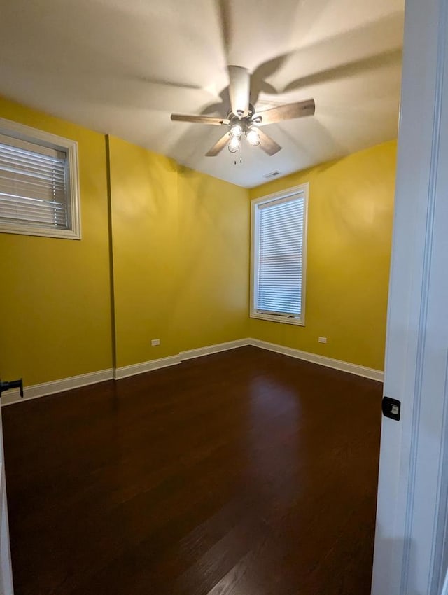 unfurnished room with ceiling fan and dark hardwood / wood-style flooring