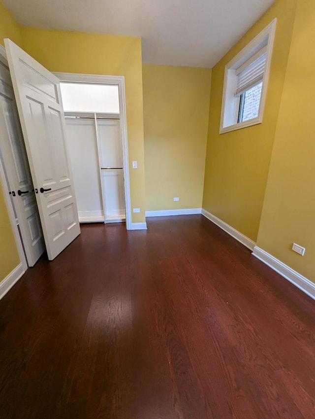 unfurnished bedroom featuring dark hardwood / wood-style flooring and a closet