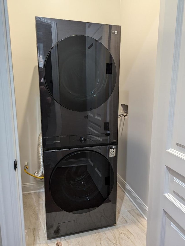 clothes washing area featuring stacked washer / dryer