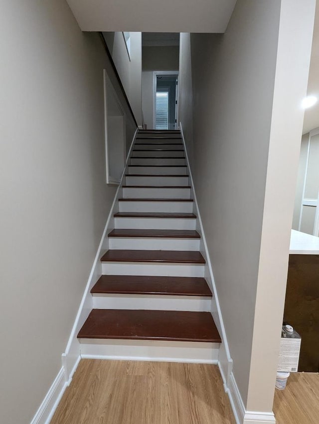 stairs featuring hardwood / wood-style floors