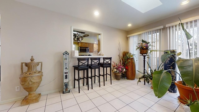 tiled dining space featuring a skylight