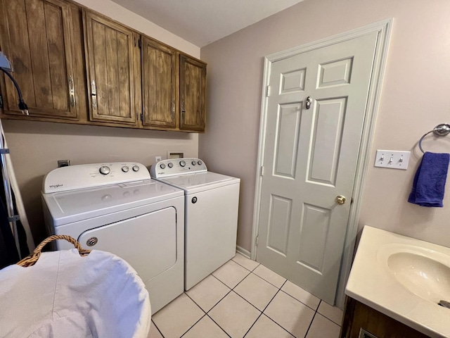 laundry room featuring sink, cabinets, washer and clothes dryer, and light tile patterned floors