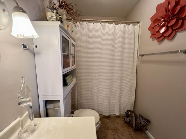 bathroom featuring toilet, tile patterned flooring, vanity, and curtained shower