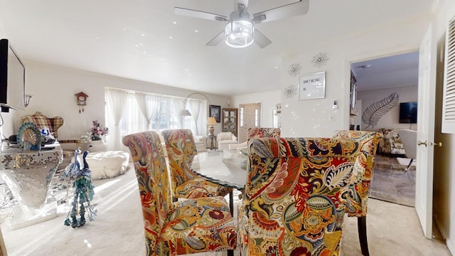 dining room with ceiling fan and light colored carpet