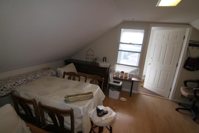 bedroom featuring wood-type flooring and vaulted ceiling