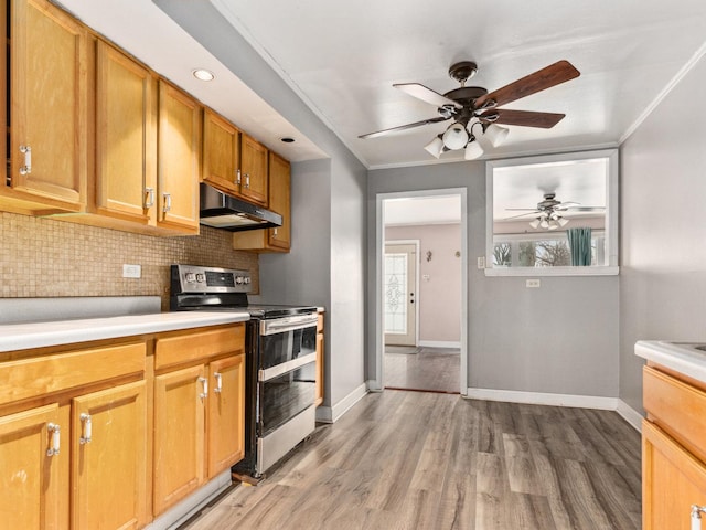 kitchen with crown molding, ceiling fan, light wood-type flooring, stainless steel range with electric cooktop, and decorative backsplash