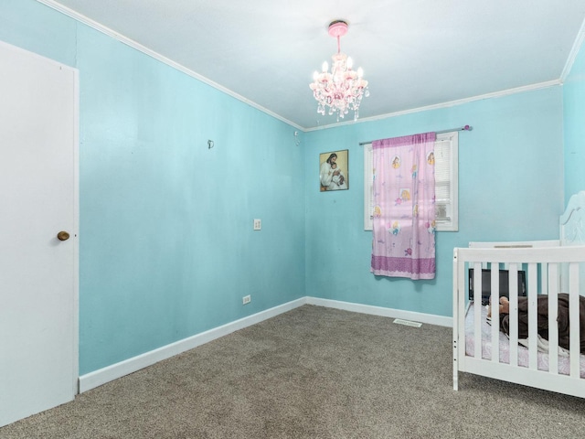 unfurnished bedroom with a crib, carpet floors, a notable chandelier, and ornamental molding