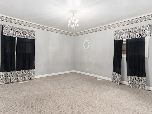 carpeted spare room featuring a notable chandelier