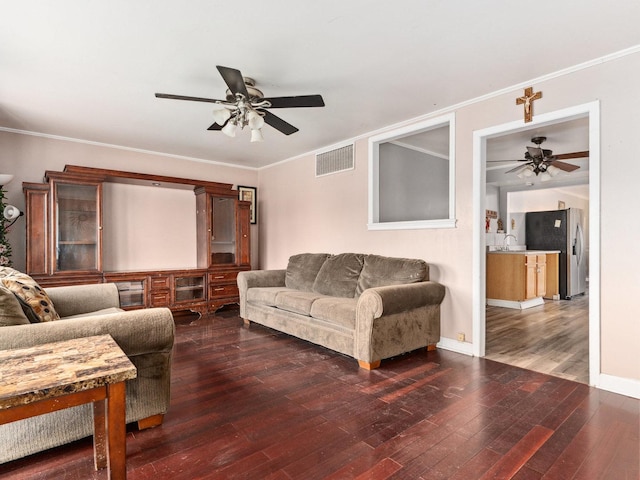 living room featuring sink, ceiling fan, crown molding, and dark wood-type flooring