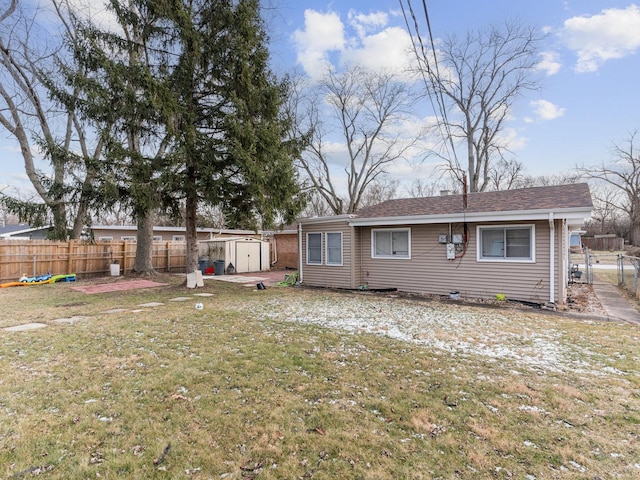 back of property with a storage unit and a lawn