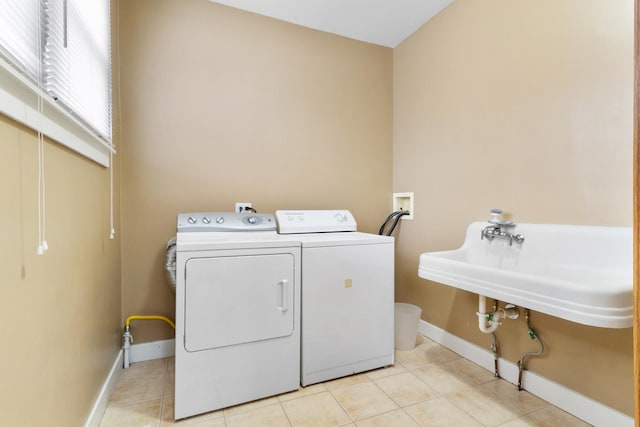 washroom with separate washer and dryer, sink, and light tile patterned floors