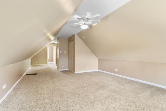 additional living space with ceiling fan, light colored carpet, and vaulted ceiling