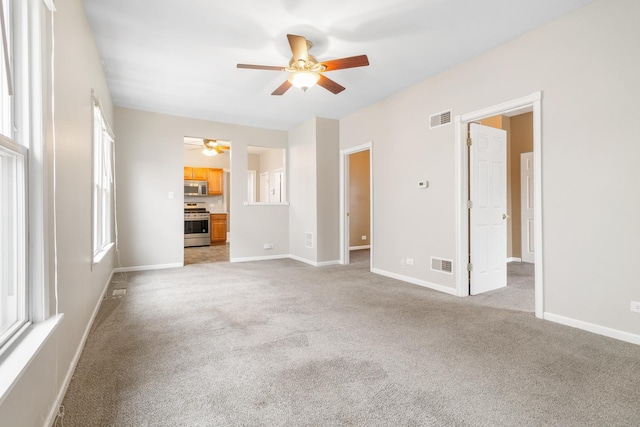 unfurnished living room with a healthy amount of sunlight and light carpet