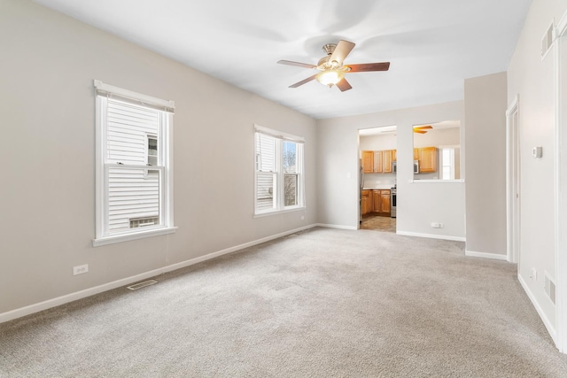 unfurnished living room featuring light colored carpet and ceiling fan