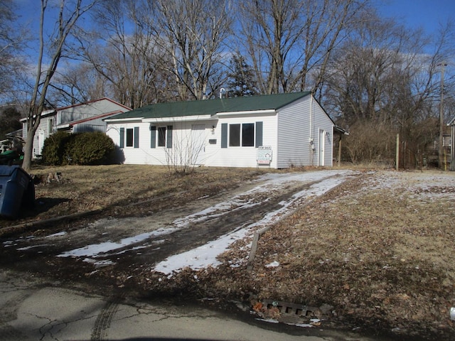 ranch-style home with driveway and metal roof