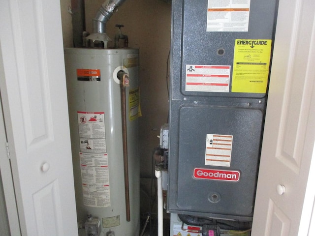 utility room featuring gas water heater and heating unit