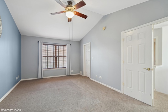 unfurnished room featuring ceiling fan, light colored carpet, and vaulted ceiling