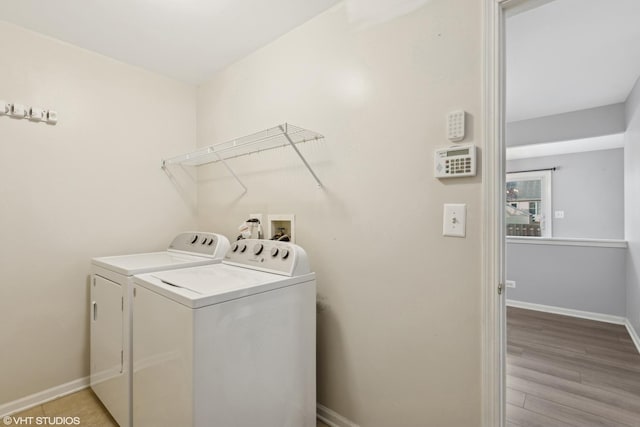 clothes washing area featuring light wood-type flooring and washing machine and dryer