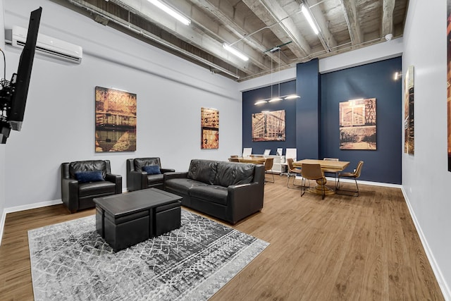 living room featuring wood-type flooring and an AC wall unit