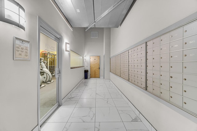 hallway featuring mail boxes and a high ceiling