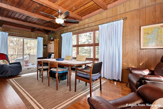 dining room featuring hardwood / wood-style flooring, beam ceiling, wooden ceiling, and a wealth of natural light