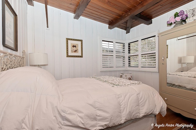 bedroom featuring beam ceiling, wood-type flooring, and wooden ceiling