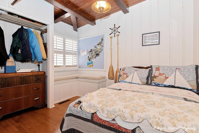 bedroom featuring lofted ceiling with beams, light hardwood / wood-style flooring, and wood ceiling