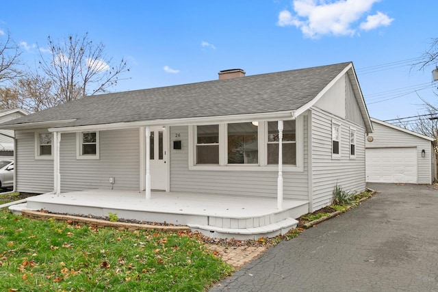 ranch-style home with an outbuilding, a porch, and a garage