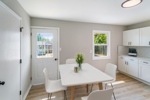 dining area with light wood-type flooring and a wealth of natural light