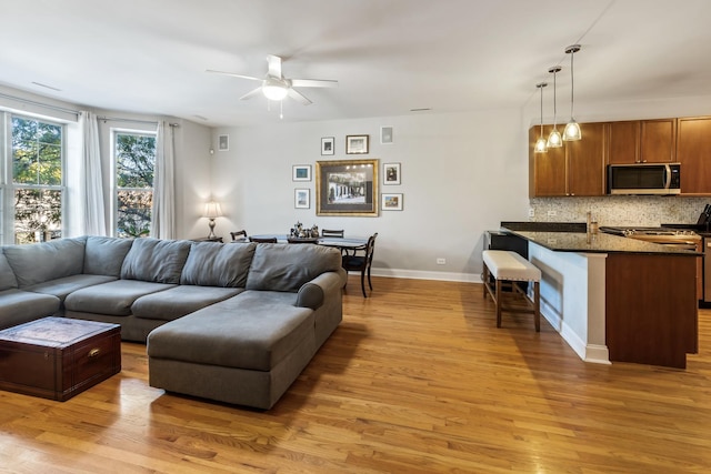 living room with light hardwood / wood-style flooring and ceiling fan