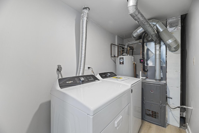 laundry area featuring gas water heater, washer and clothes dryer, and light hardwood / wood-style floors