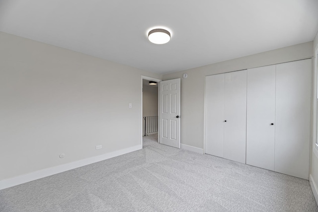 unfurnished bedroom featuring a closet and light carpet