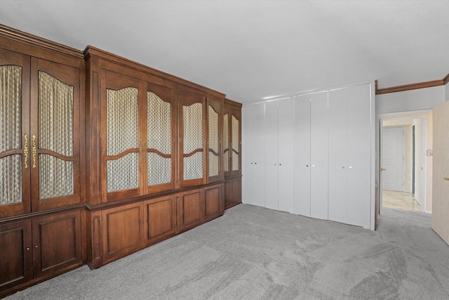 unfurnished bedroom featuring crown molding and light colored carpet