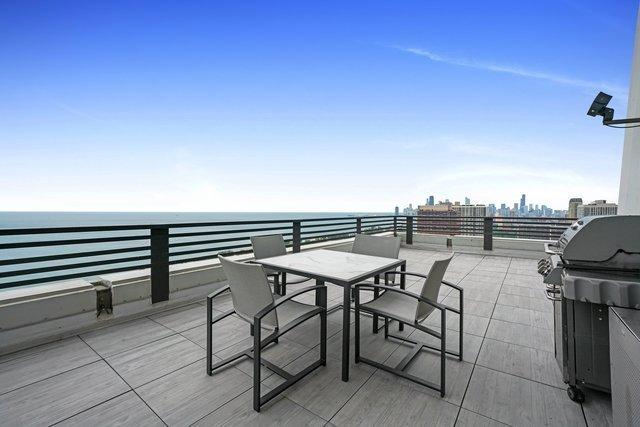 view of patio with area for grilling and a water view