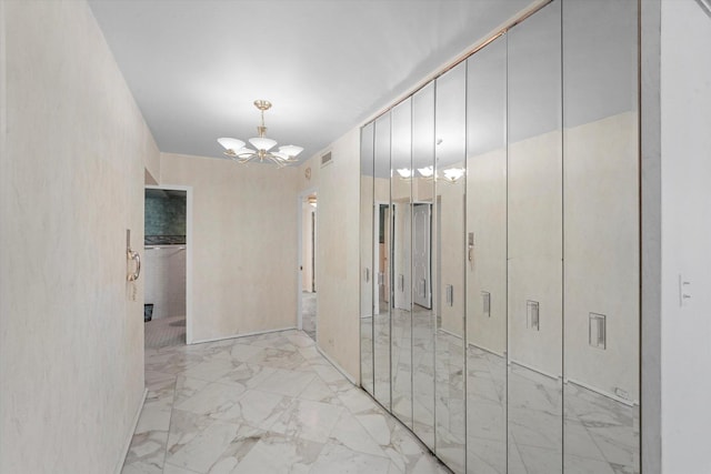 hallway with a notable chandelier